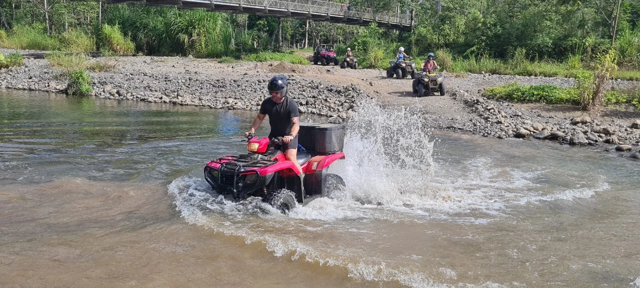 ATV rider crossing a river near Manuel Antonio, Costa Rica