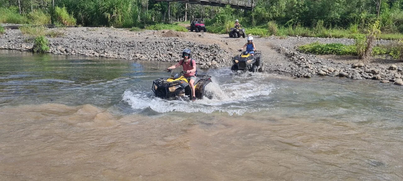 ATV rider making a splash while crossing a river