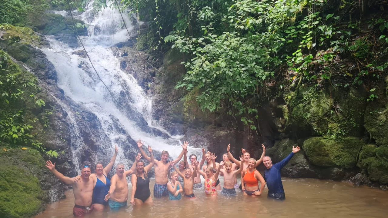 Travelers swimming together at a waterfall on the ATV tour